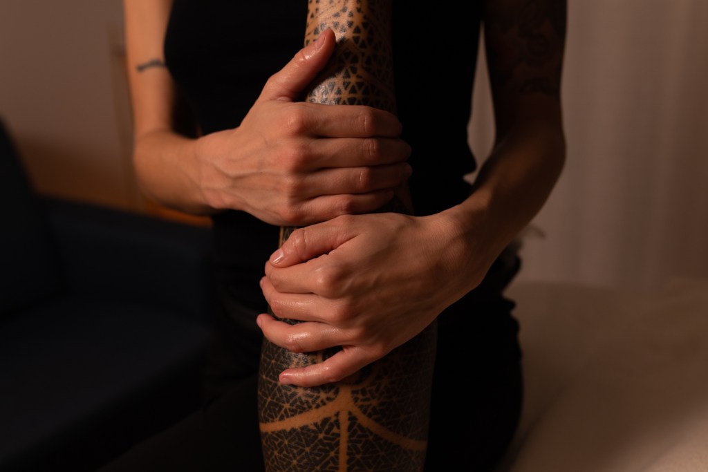 masseuse prodiguant un massage sportif en massant les mollets avec ses mains 